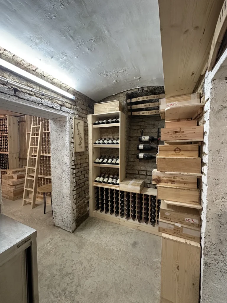 Cave voûtée en brique à Vienne aménagée sur mesure, rangements bois et échelle