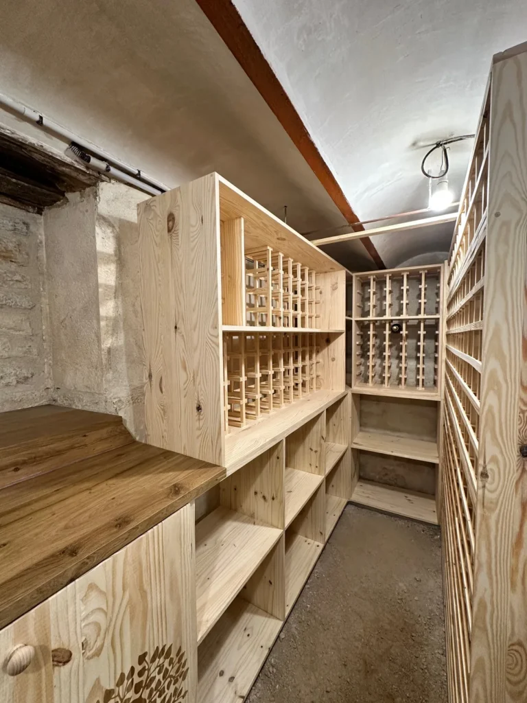 Meuble central et plan de travail en bois massif dans une cave à vin sur mesure