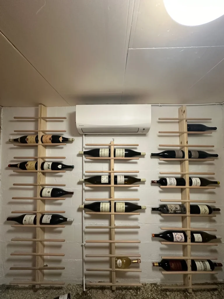 Racks muraux de présentation verticale des bouteilles dans une cave à vin sur mesure