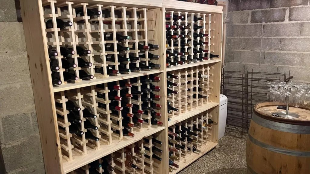 Cave à vin sur mesure réalisée à Beaune : casiers en bois massif garnis de bouteilles, réalisation du Menuisier de la Cave