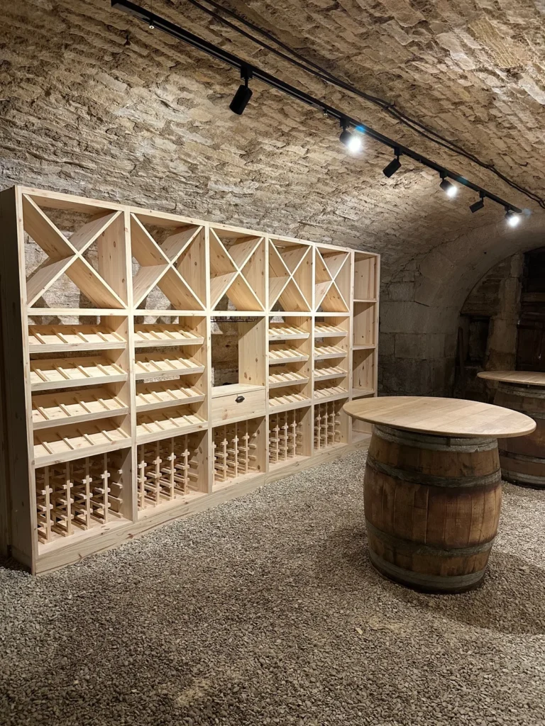 Cave à vin voûtée aménagée sur 4 mètres linéaires en Côte-d’Or, rail d’éclairage LED et fût-plateau en chêne