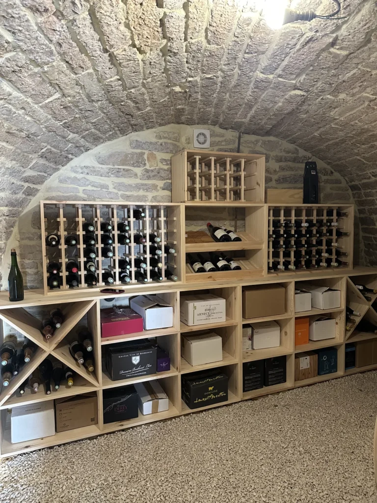 Casiers en X et rangements pour caisses bois dans une cave à vin voûtée en Côte-d’Or