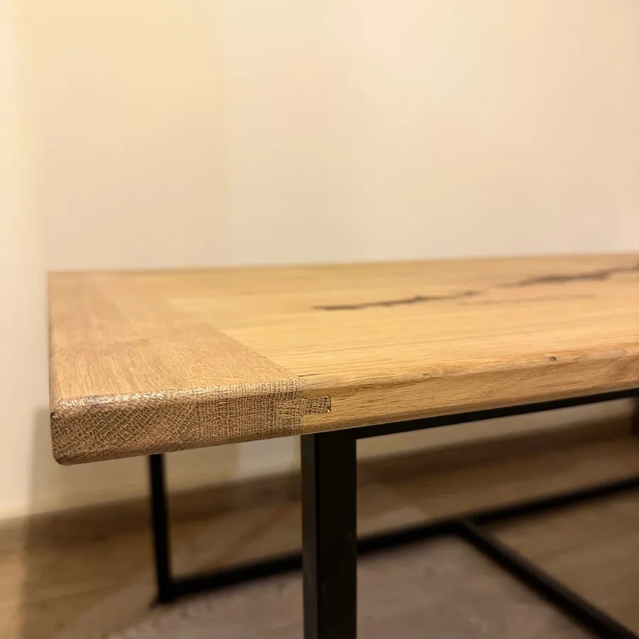 Détail du plateau en chêne massif et du pied métal noir d’une table basse sur mesure