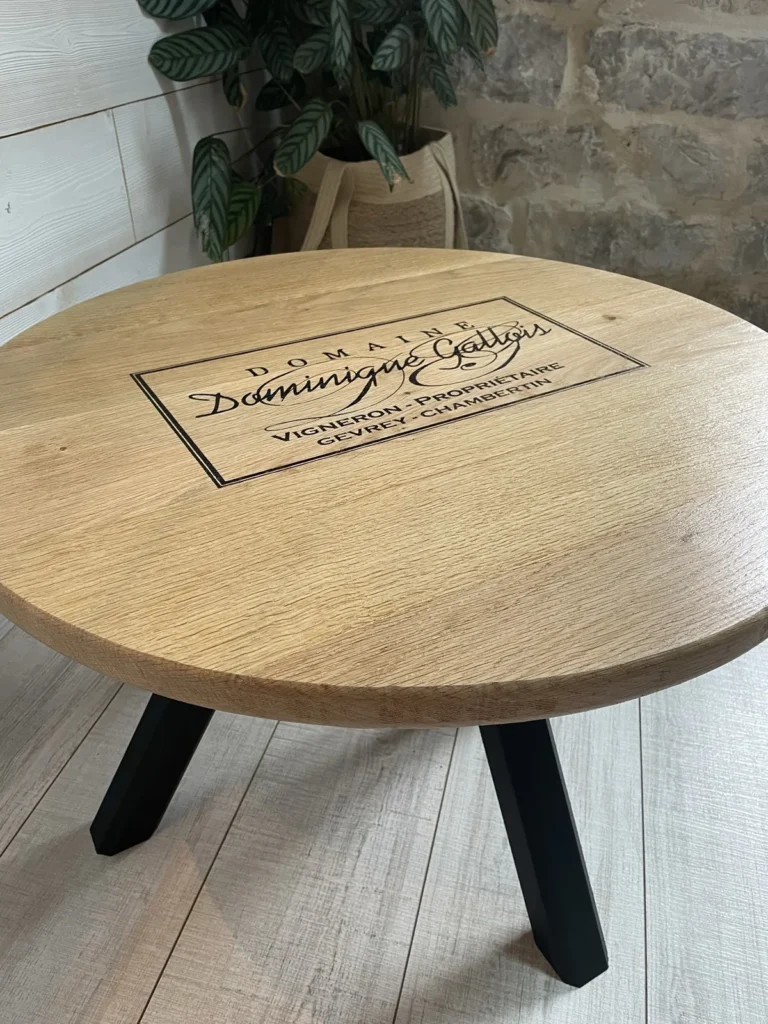 Table basse ronde en chêne gravée au nom d’un domaine viticole, personnalisation sur mesure