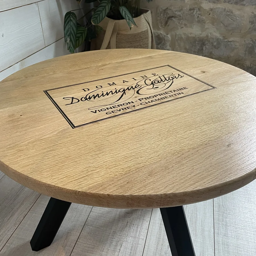 Table basse ronde en chêne gravée au nom d’un domaine viticole, personnalisation sur mesure