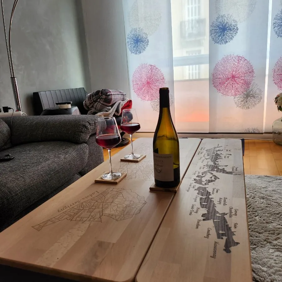Table basse viticole en chêne gravée du vignoble, dans un salon lumineux